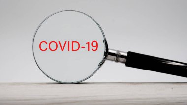 Hafif bir arkaplanda büyüteç. Kelime ya da metin cavid 19 Koronavirüsü koru,