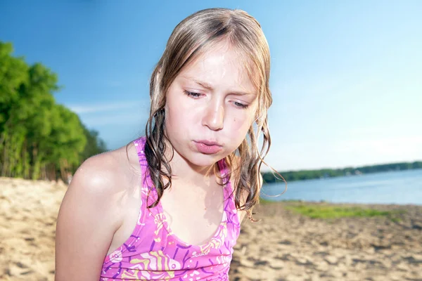 Hermosa chica en la playa en el primer plano de verano viendo algo. En el fondo de un bosque y un lago. — Foto de Stock