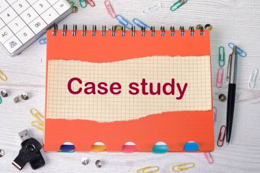 Hesap makinesi, kalem ve USB flaş belleğin yanında yırtık bir kağıt parçasına yazılmış bir vaka çalışması