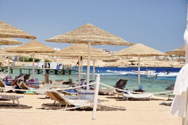 Sahilde güneşlenen şemsiyeler denizin arka planında dinlendirici bir tatil için.