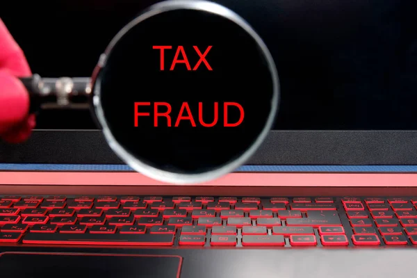 Computer monitor with red text Tax fraud through a magnifying glass — Stock Photo, Image