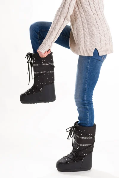 Chica en botas de luna de invierno, jeans y suéter en un fondo blanco —  Fotos de Stock