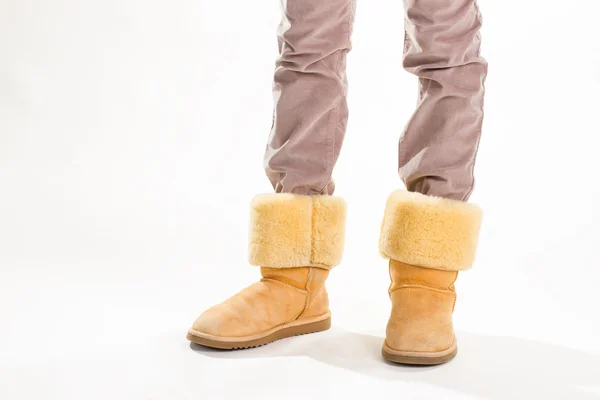 Menina no inverno amarelo engraçado botas australianas . — Fotografia de Stock