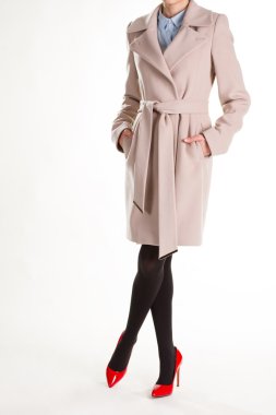 Kırmızı ayakkabılar ve bej bir palto.