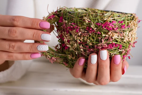 Menina com uma bela manicure segurando uma xícara de feno . — Fotografia de Stock