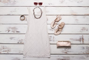 Beyaz elbise ile bej sandalet.