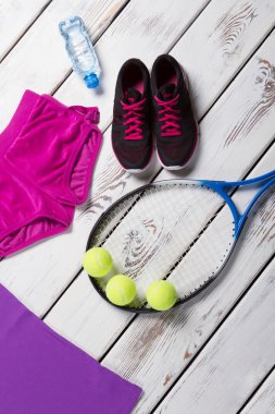 Koyu spor ayakkabı, tenis raketi.
