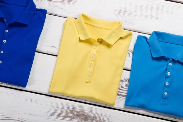 T-shirts marinhas, amarelas e azuis . — Fotografia de Stock