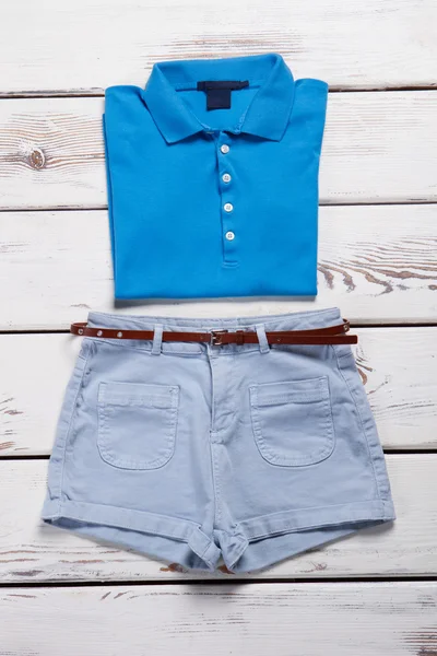 Blauwe polo shirt en lichte jeans shorts. — Stockfoto