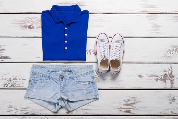 Blauwe polo shirt en lichte jeans shorts. — Stockfoto