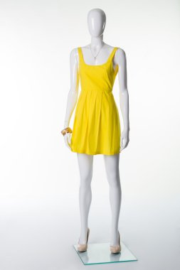 Manken sarı yaz elbise ve bej topuklu ayakkabılar.