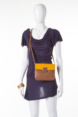 Güzel şık elbise beyaz bir manken üzerinde bir çantalı. 