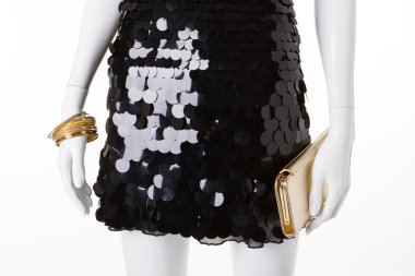 Altın aksesuarlar ile siyah gece elbisesi.