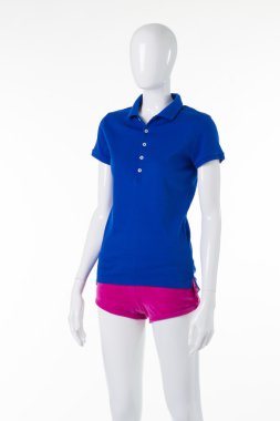 Mavi polo gömlek ve beyaz bir manken üzerinde pembe şort.