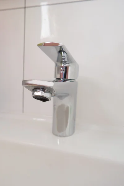 Shiny clean faucet on a background of white tiles. — Stock Photo, Image