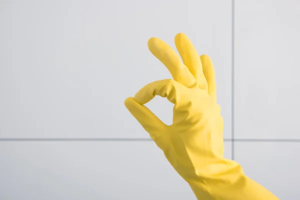 Hand in gelbem Gummihandschuh zeigt ok. — Stockfoto