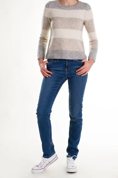 Girl in knitted sweater, blue jeans and white sneakers. — Stock Photo, Image