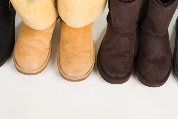 Botas de invierno oscuras y ligeras sobre fondo blanco . — Foto de Stock