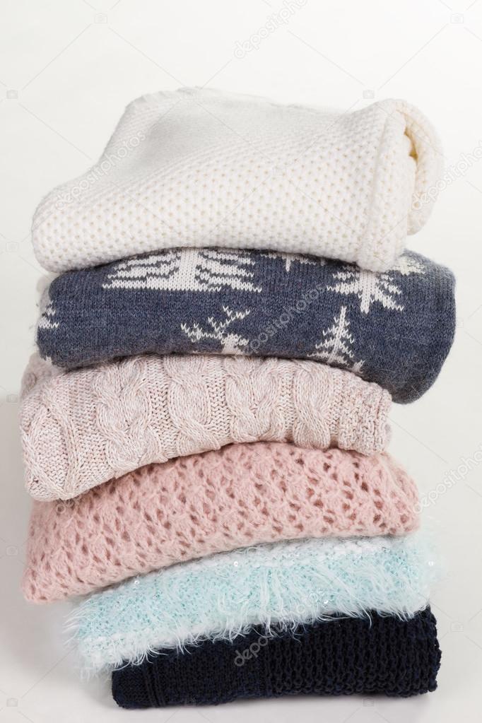 Stack of beautiful handmade sweaters with different patterns. 