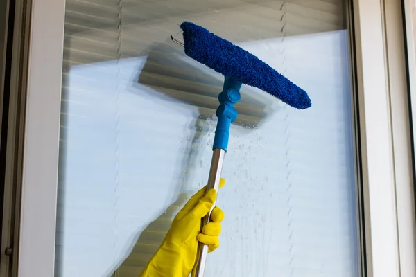 Cleaning windows  in yellow gloves — Stock Photo, Image