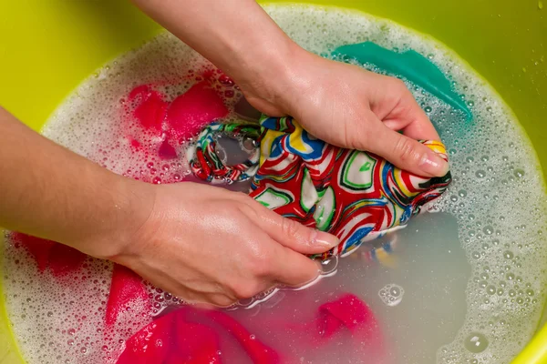 Vrouwelijke hand wassen kleren. — Stockfoto