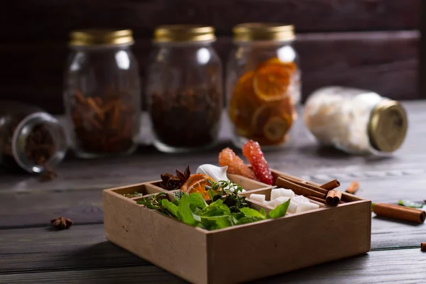Tea box on a background of glass jars with spices. — Stock Photo, Image
