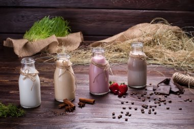 ahşap arka plan üzerinde çeşitli doğal milkshakes.