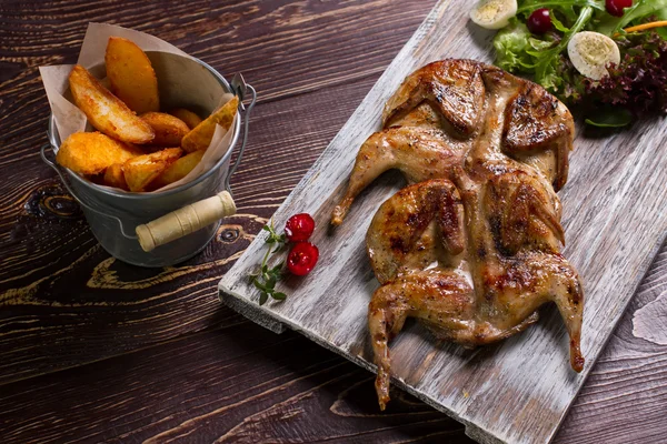 Roasted quails on a wooden board. — Stock Photo, Image