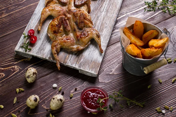 Roasted quails on a wooden board. — Stock Photo, Image