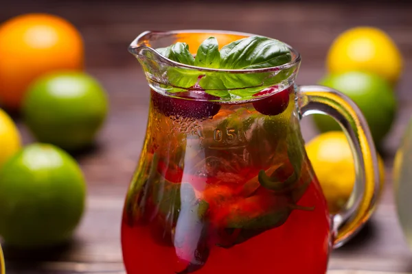 Jug of freshness lemonade with strawberries and cranberry. — Stock Photo, Image