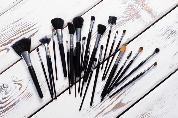 Makeup brushes  on a white wooden board. — Stock Photo, Image