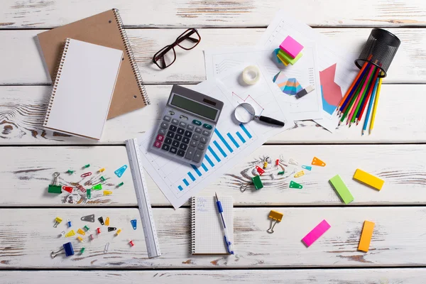 Papelería esparcida sobre un fondo de madera . — Foto de Stock