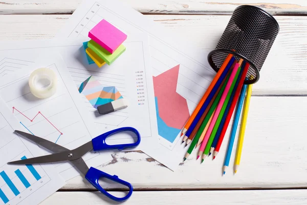 Stationery with graphs on a white wooden table. — Stock Photo, Image
