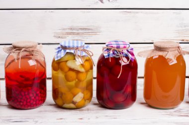 Canned compotes in large glass jars. clipart