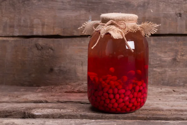 Homemade compote of dogwood on wooden boards. — Stock Photo, Image