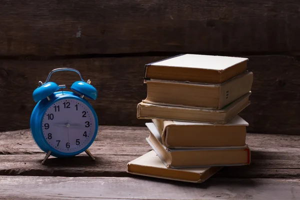 Relógio e livros no interior escuro . — Fotografia de Stock