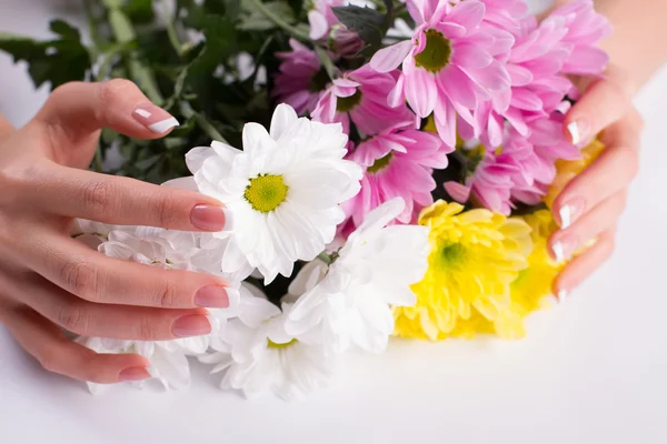 Smuk fransk manicure på baggrund af blomster . - Stock-foto