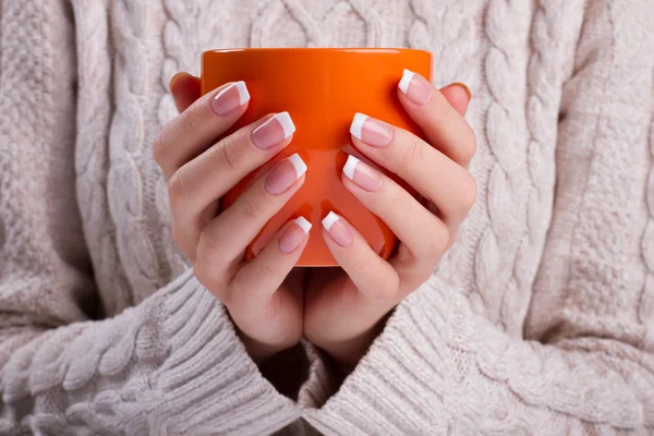 Mujer sostiene una taza naranja de cerca . —  Fotos de Stock