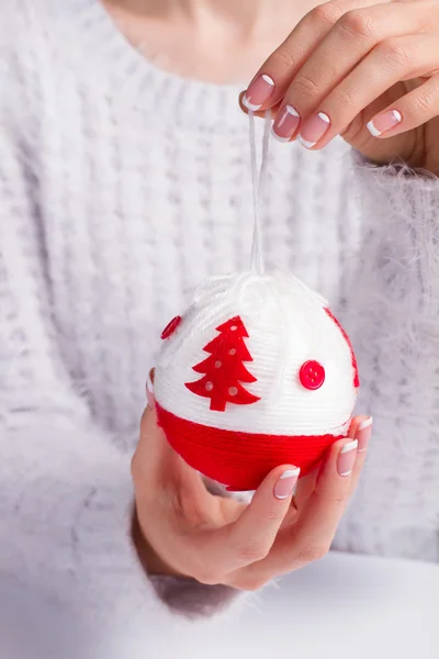 Fille dans un beau pull moelleux tenant une boule de Noël . — Photo