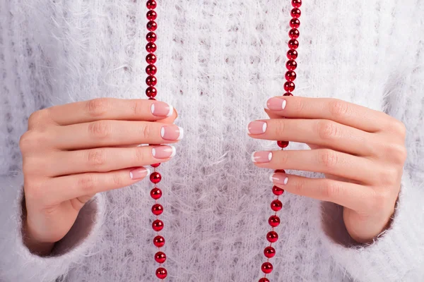 Female fingers holding a red necklace. — Stock Photo, Image