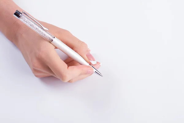 Bela mão feminina com manicure segurar uma caneta . — Fotografia de Stock