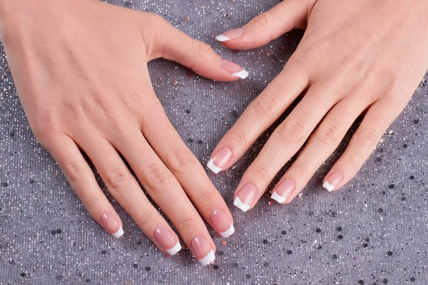 Delikatny Francuski manicure na srebrnym tle. — Zdjęcie stockowe