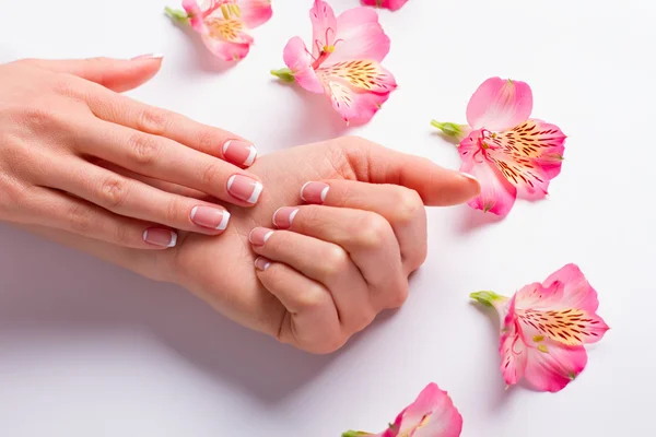 Vrouwelijke hand met delicate bloemen. — Stockfoto