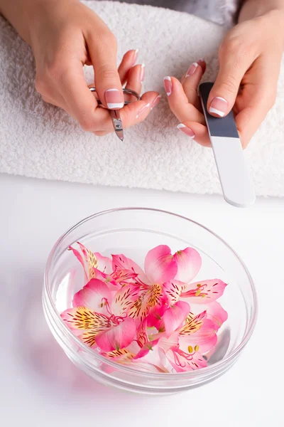 Women's hands with manicure tools.