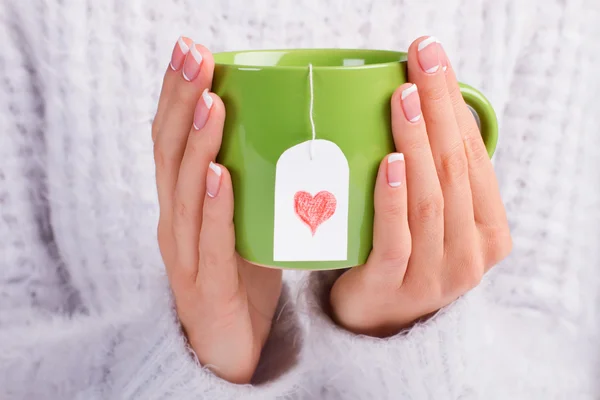 Hermosa taza verde con bolsa de té de amor . —  Fotos de Stock