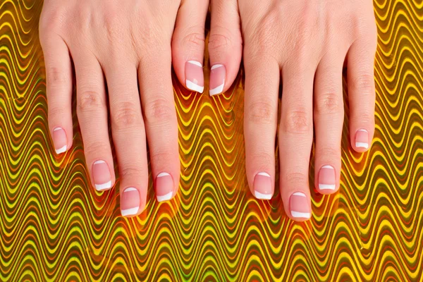 Stylowe Francuski manicure na złotym tle. — Zdjęcie stockowe