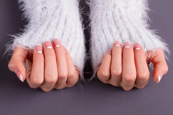 Sleeves of fluffy sweaters and french manicure.