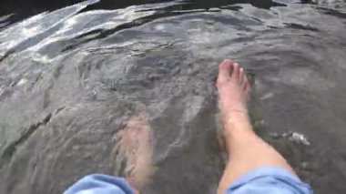 San Kamphaeng, Chiang Mai, Tayland 'da bir adam ayaklarını kaplıcada dinlenmek için ıslatır.