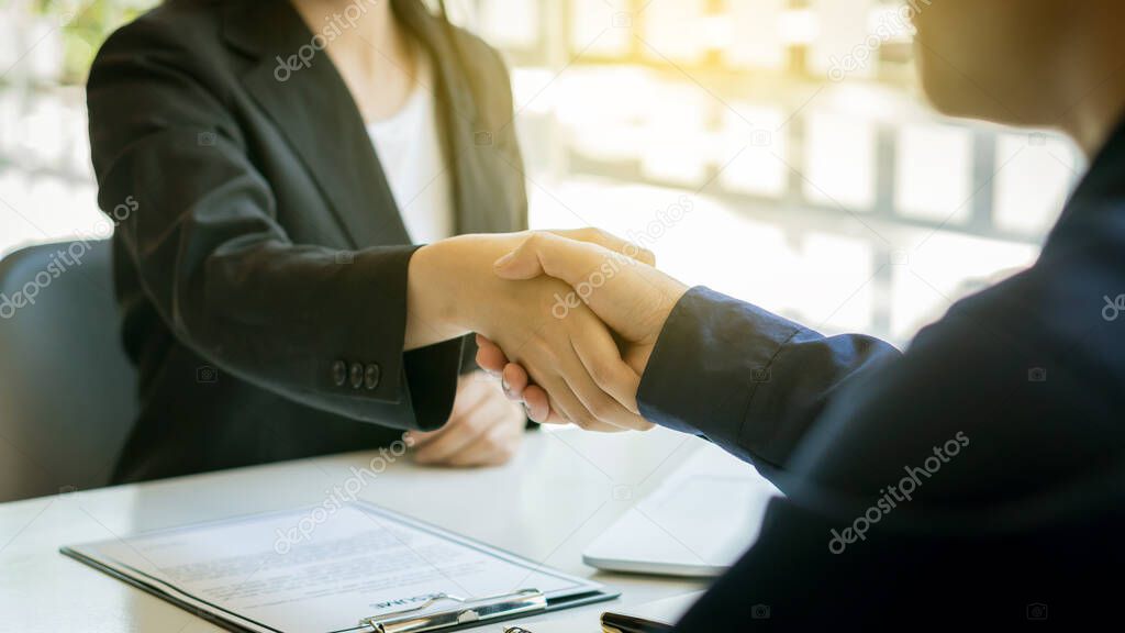 Business people shake hands with job applicants with documents and have a laptop on the table