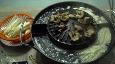 Yemek için domuz eti ve kaynamış mantarları bir arada tutan tencere tenceresi..